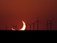 Partial solar eclipse with windmills